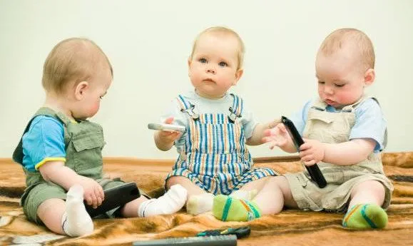 Младенцы играются с телевизионными пультами