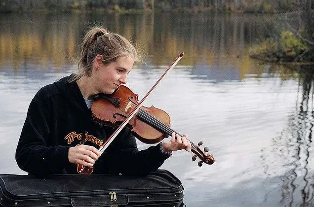 Исполнение классической музыки на скрипке у водоема