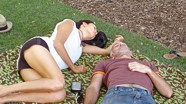 Утомленные люди отдыхают на уличном газоне