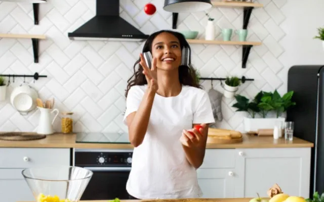 Молодая девушка жонглирует томатами на кухне