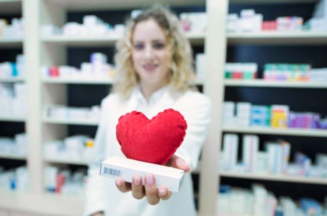 Фармацевт в белой форме держит статины от сердечно-сосудистых заболеваний