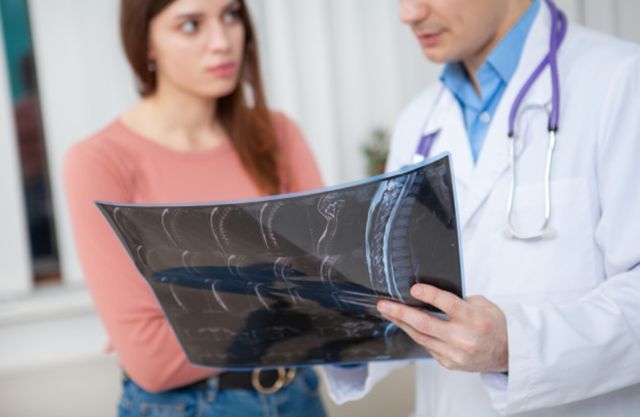 Молодая девушка обсуждает рентгеновский снимок со своим врачом