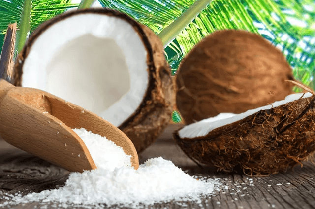 Изображение свежей кокосовой стружки на фоне пальм и плодов